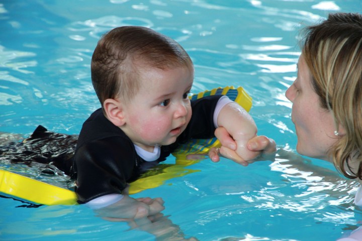 a young boy swimming in a pool of water