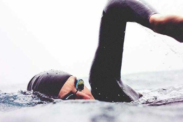 a man riding a snow board in the water